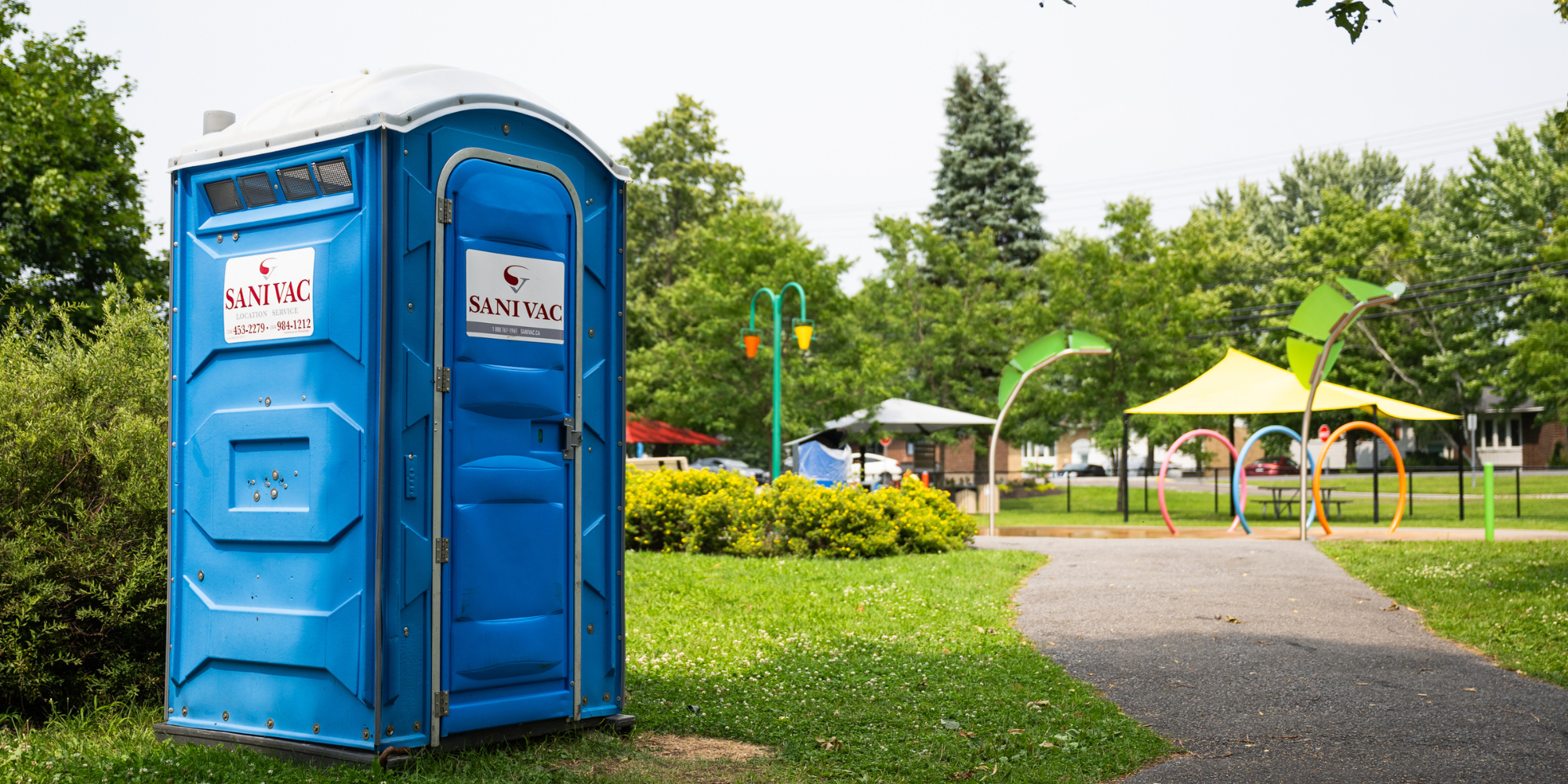 Toilette chimique Sanivac installée dans un parc public verdoyant