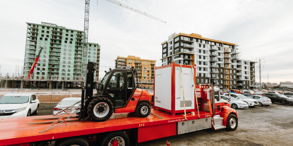 Bloc sanitaire transporté sur un chantier résidentiel en construction
