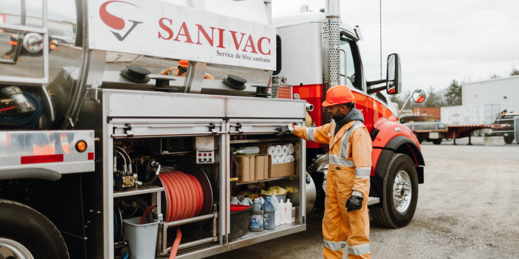 Opérateur Sanivac effectuant l’entretien de toilettes chimiques avec un camion spécialisé
