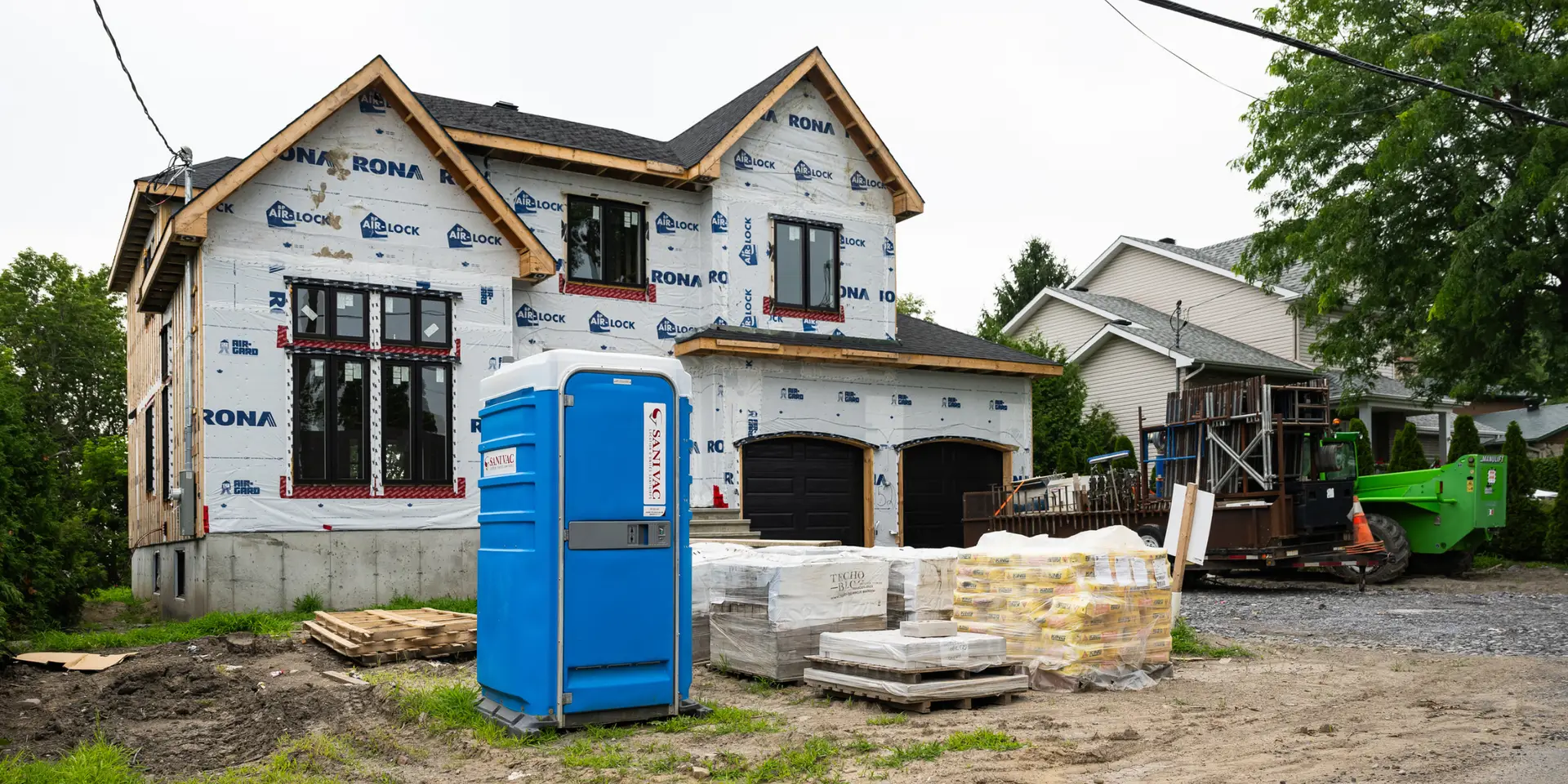 Toilette chimique en plastique sur chantier de construction résidentiel.