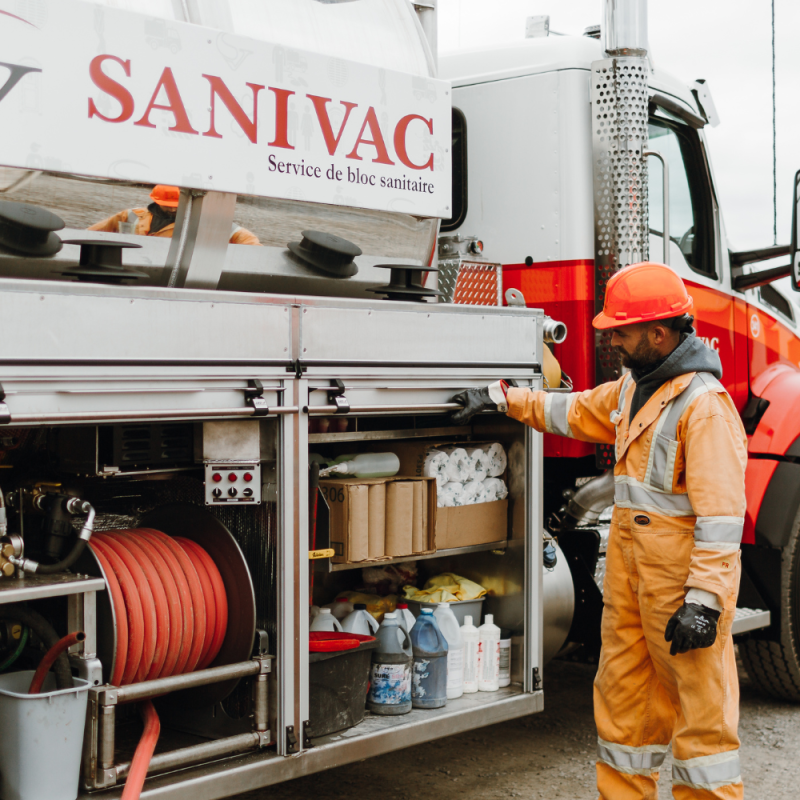 Entretien de toilettes chimiques par un opérateur Sanivac Opérateur Sanivac effectuant l’entretien de toilettes chimiques avec un camion spécialisé