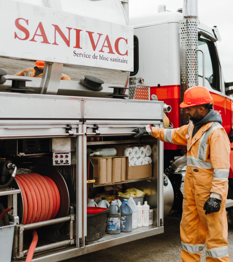 Opérateur Sanivac effectuant l’entretien de toilettes chimiques avec un camion spécialisé